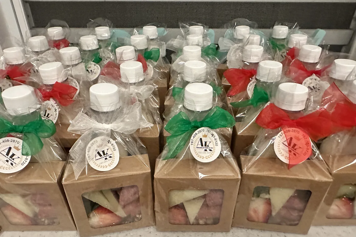 Muchas cajas de charcutería individuales con lazos y la etiqueta de A&K, listas para entregar