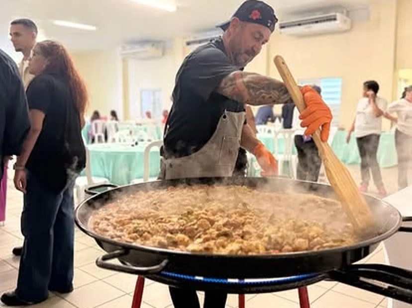 El chef Ángel revolviendo la paella con el vapor subiendo durante un evento
